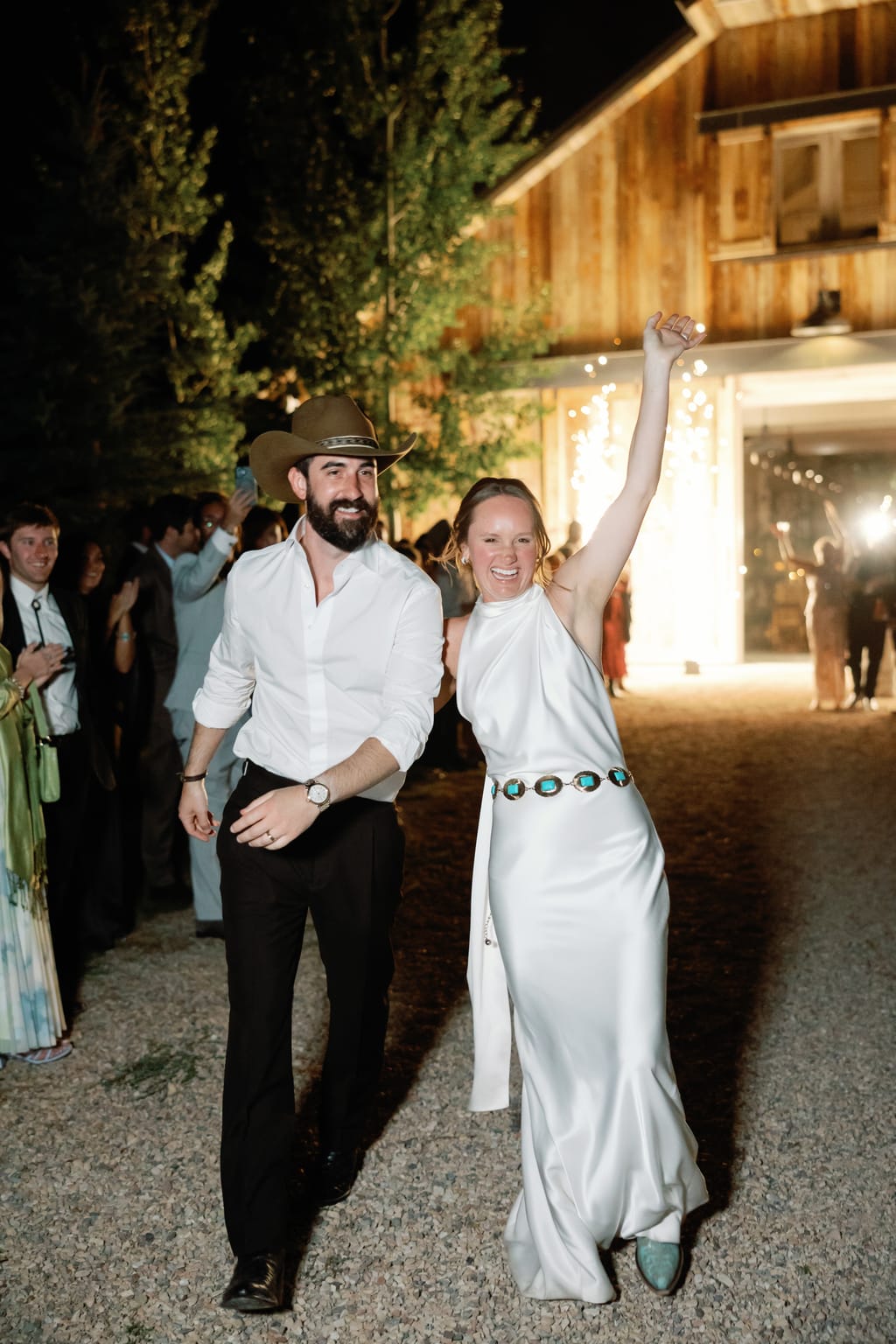 Bride and groom walk together by the barn at dusk, a 4U Ranch wedding in Park City, Utah