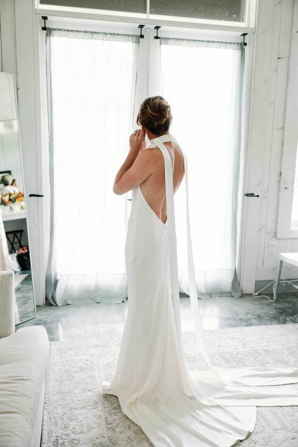 Bride in an open-back gown by the window before her 4U Ranch wedding in Park City, Utah