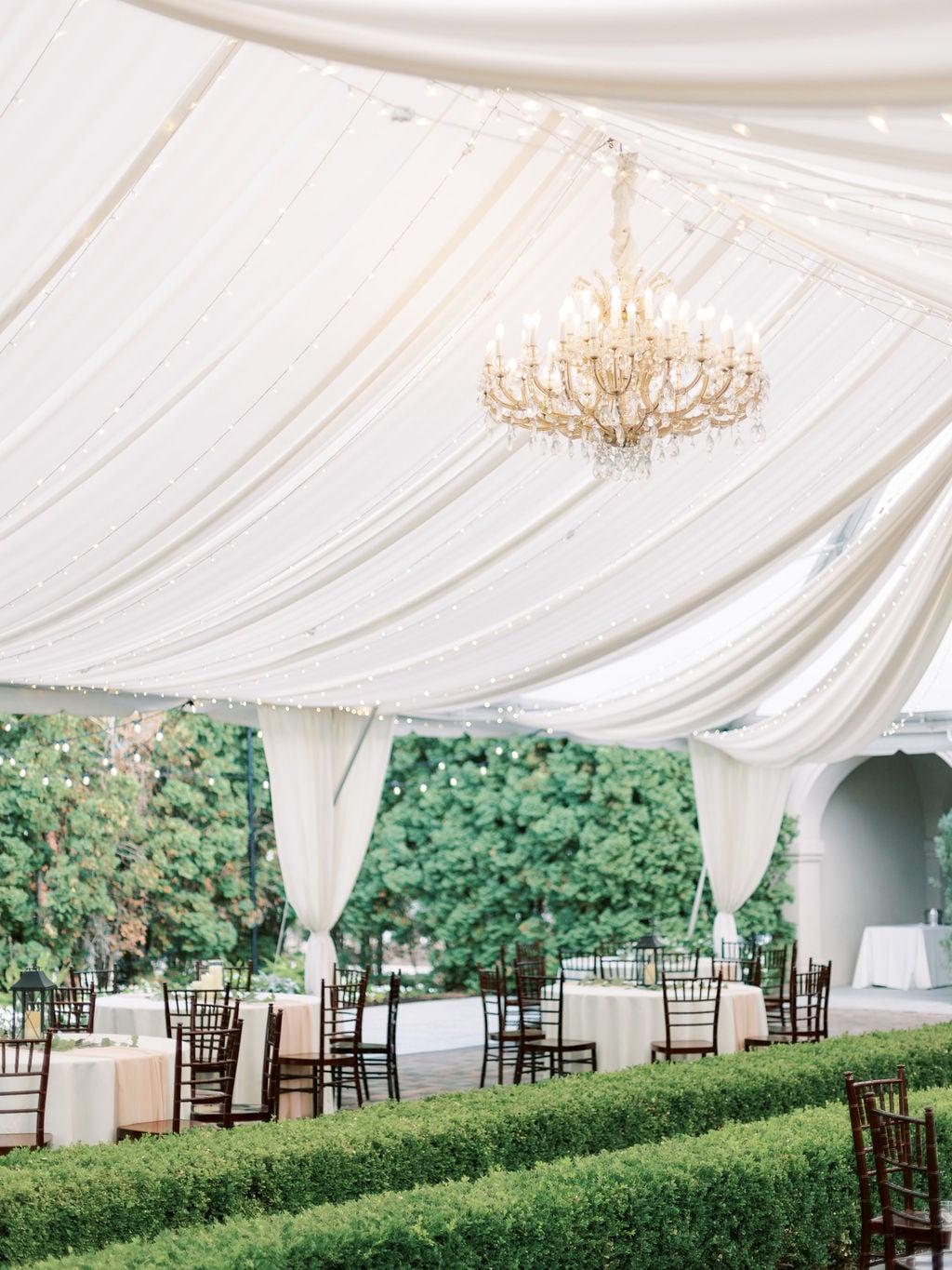 The tented reception under chandeliers at Ashton Gardens, Thanksgiving Point