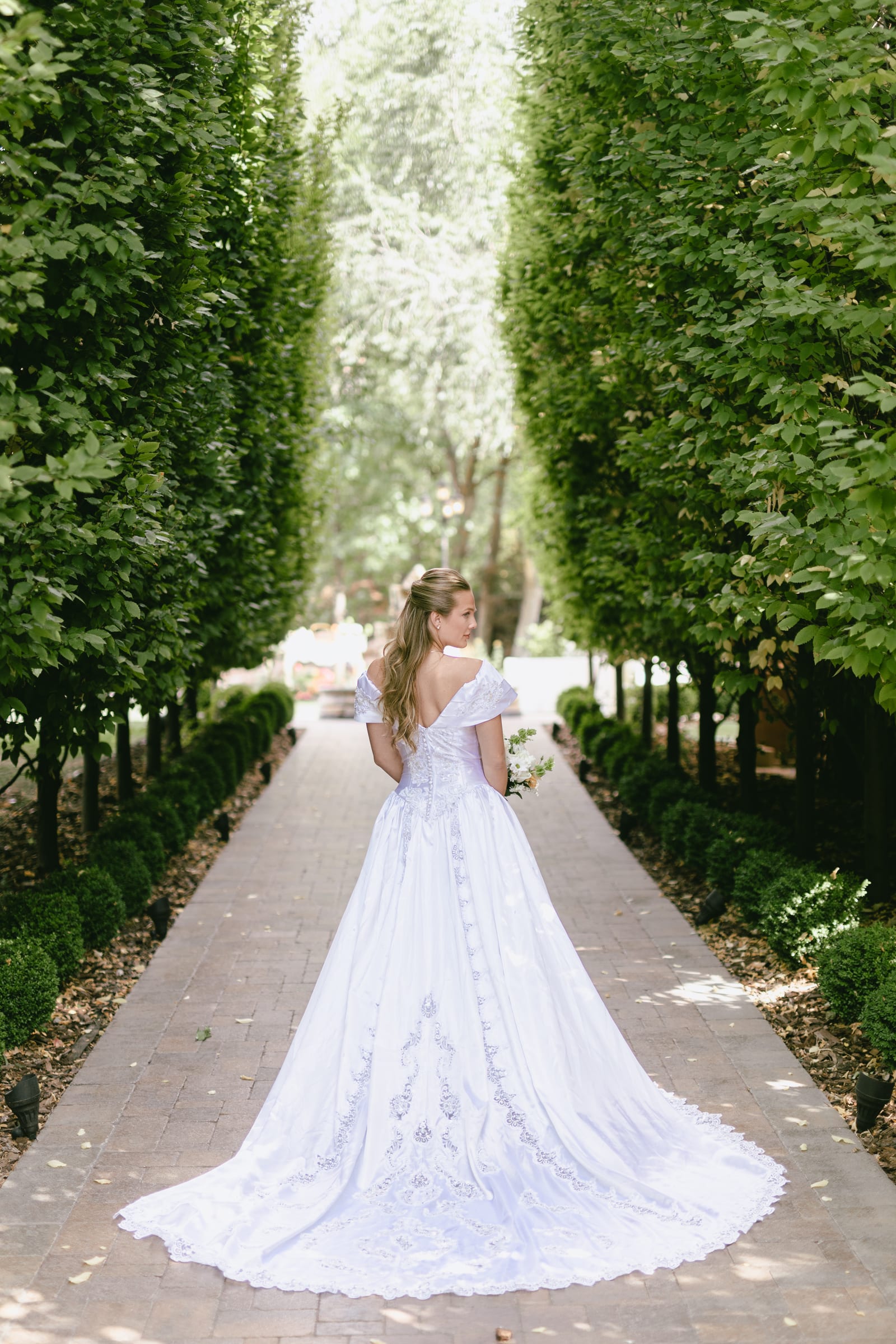 Kyle and Marita wedding at Bellissimo Gardens, the gown in the garden alley