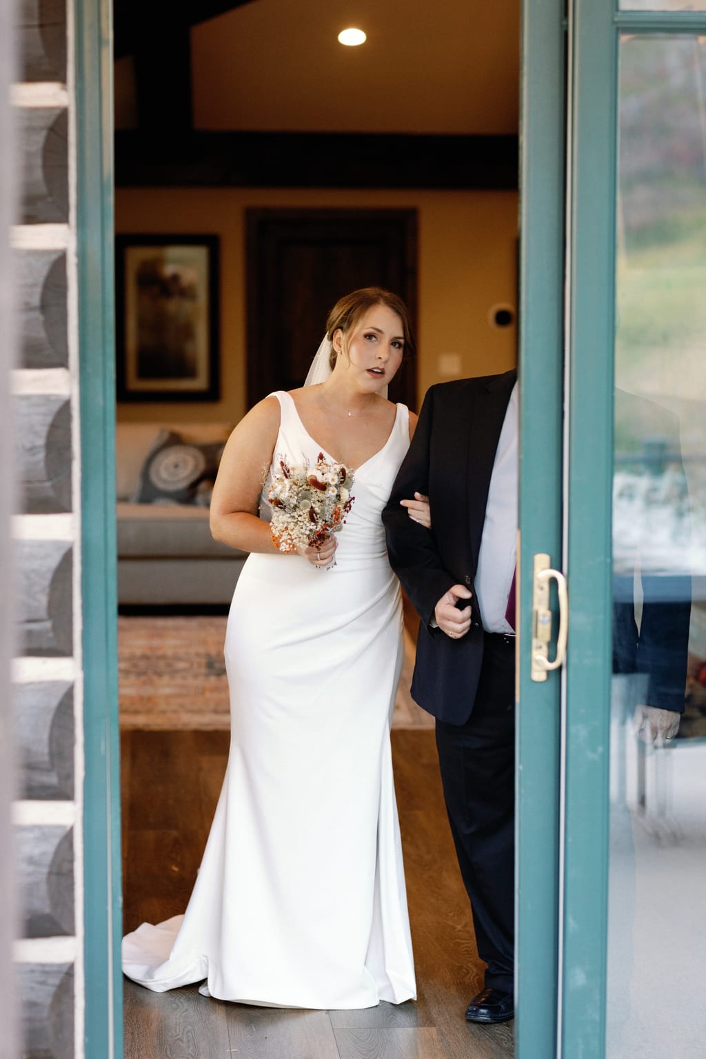 The bride in the doorway with her bouquet before walking down the aisle, Sundance residence