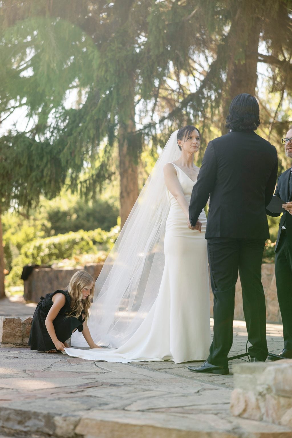 The first kiss at the altar with the veil and string lights, a Utah garden ceremony